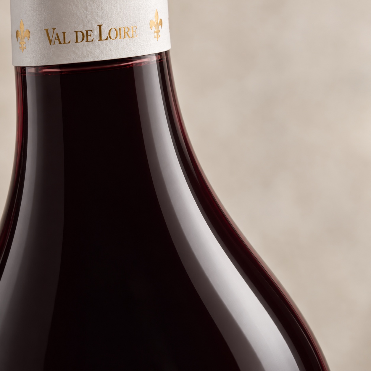 Détail du col, de la capsule Val de Loire et des reflets du vin rouge sombre
